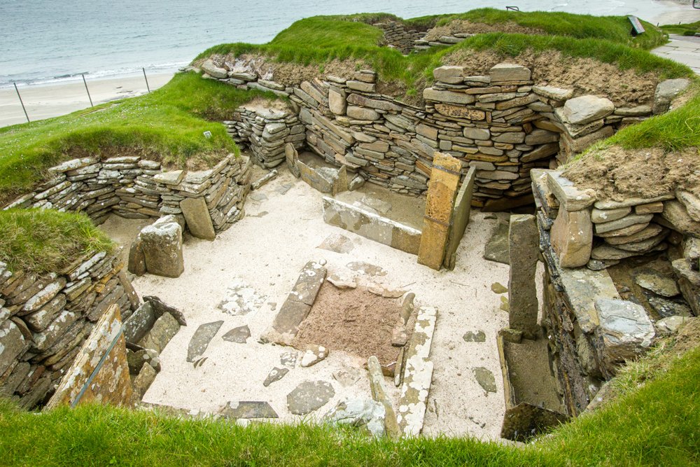 Photo of Skara brae interior showing stone furniture and hearth